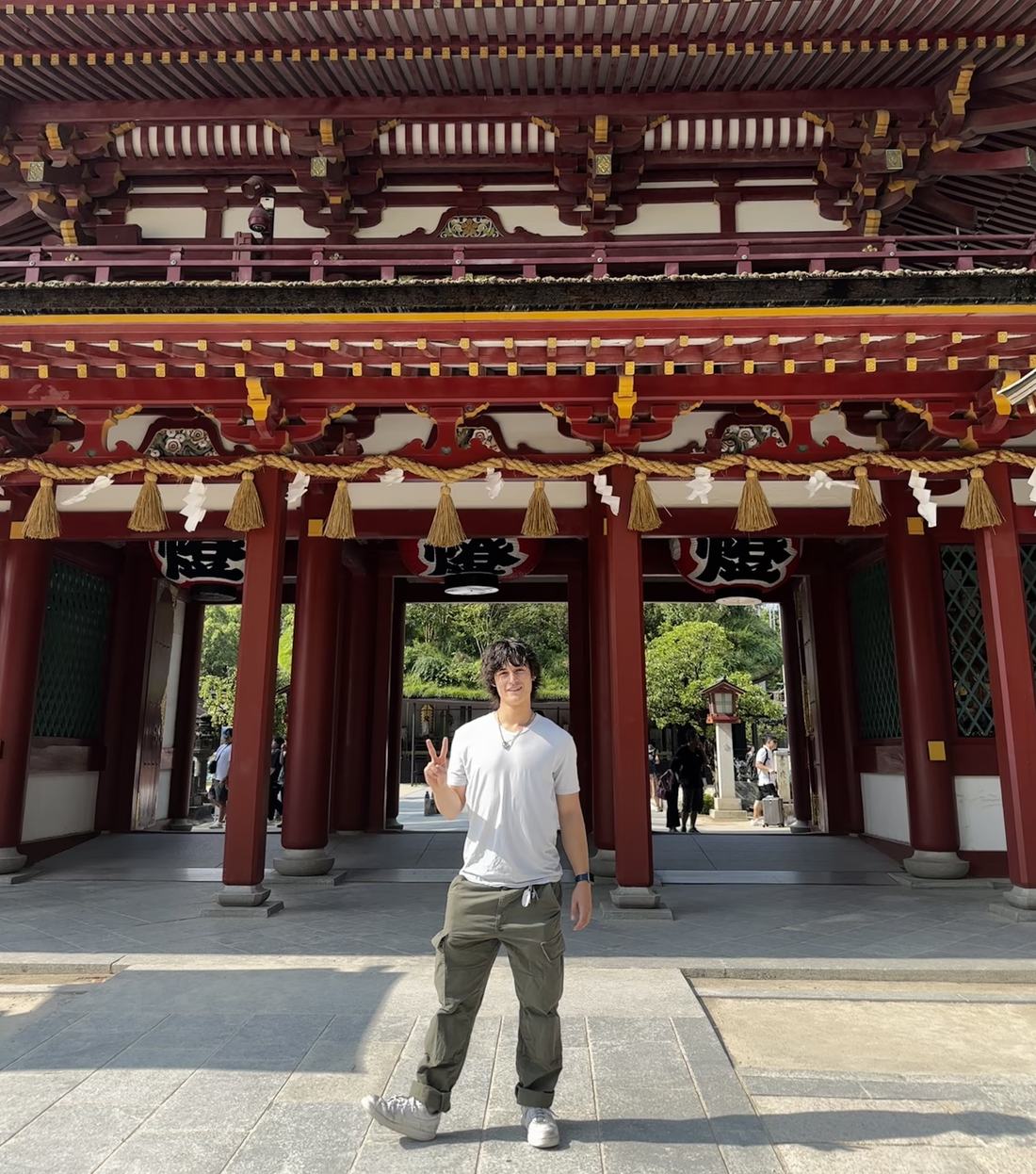 Jared standing under a vermilion shrine gate in Fukuoka